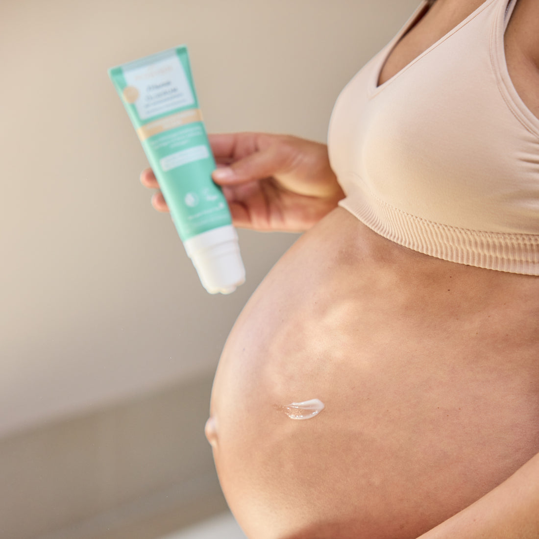 Mama mit Babybauch und Ölserum